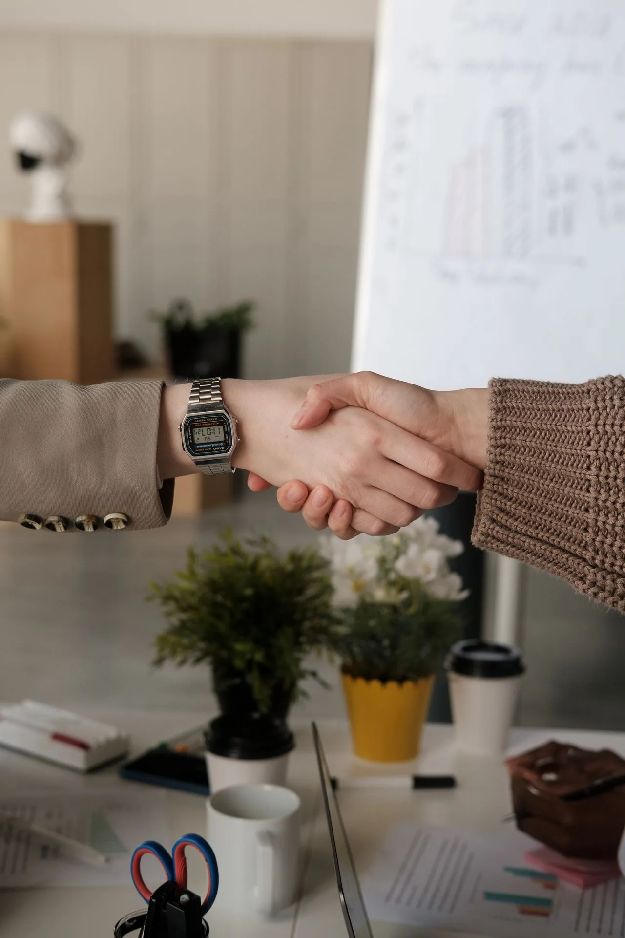 테이블 위에서 자연스럽게 악수하는 두 사람의 손